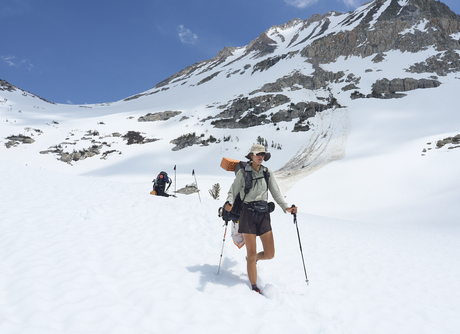 A hiker crosses the runout zone of a wet snow avalanche.