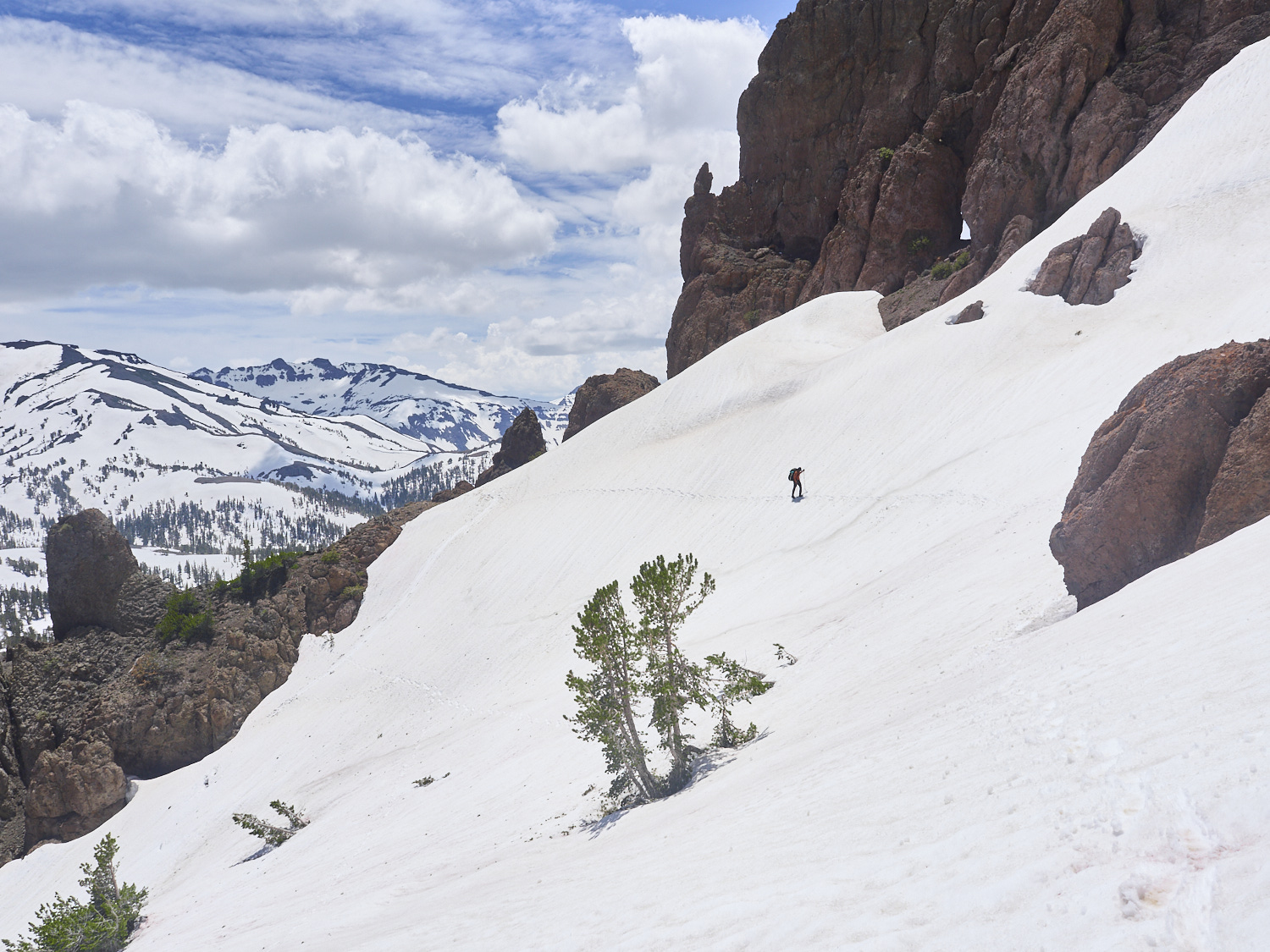 A hiker fights his way up a steep, snow-covered slope of Sonora Peak at over 3,000 meters elevation.