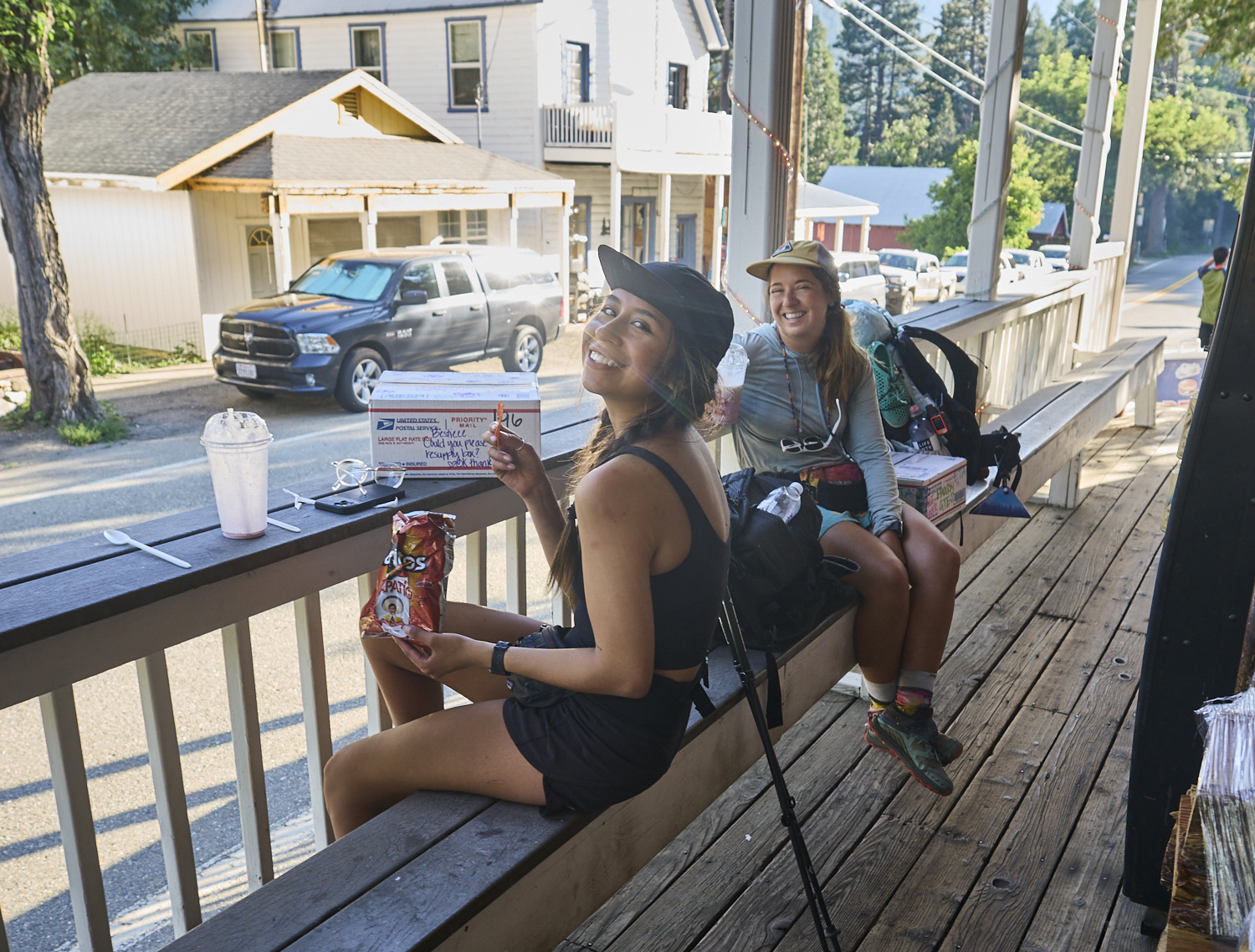 Two hikers sitting on the porch of the Sierra City general store.