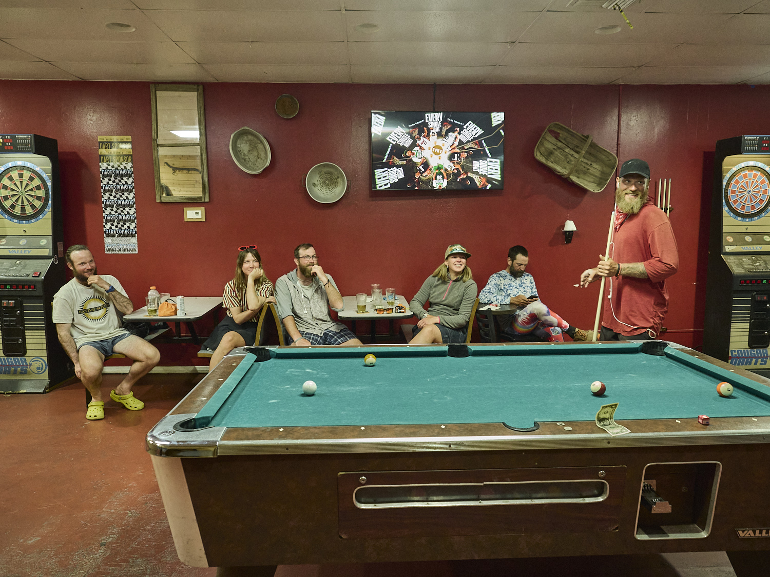 hikers are enjoying a game of pool and some beer at a saloon in Bishop
