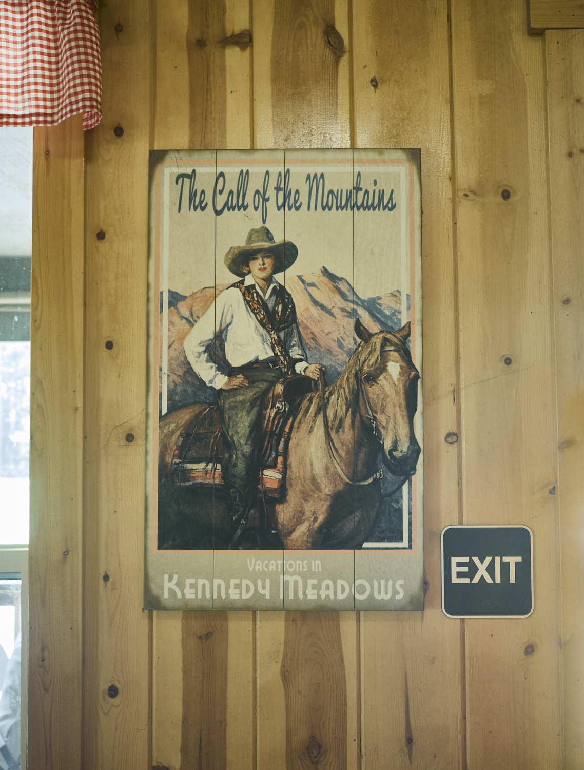 a picture on a wall of a restaurant showing a young woman with a cowboy hat riding on a horse