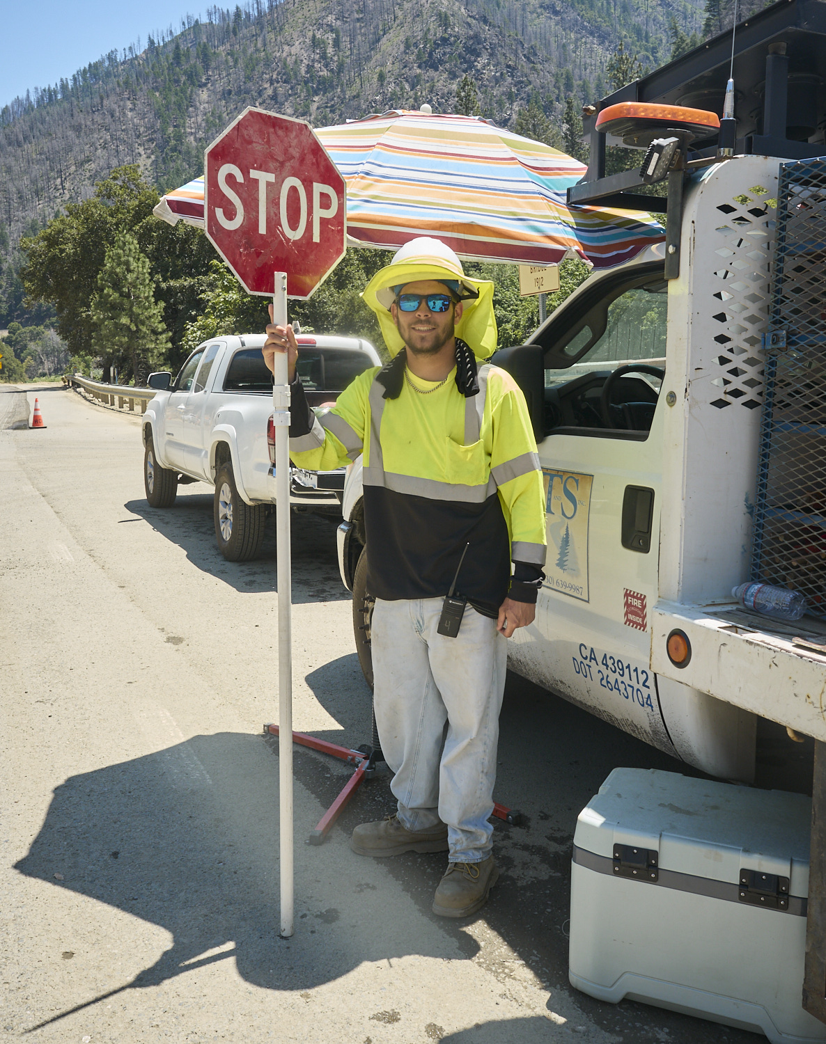 A road construction worker is holding a Stop sign