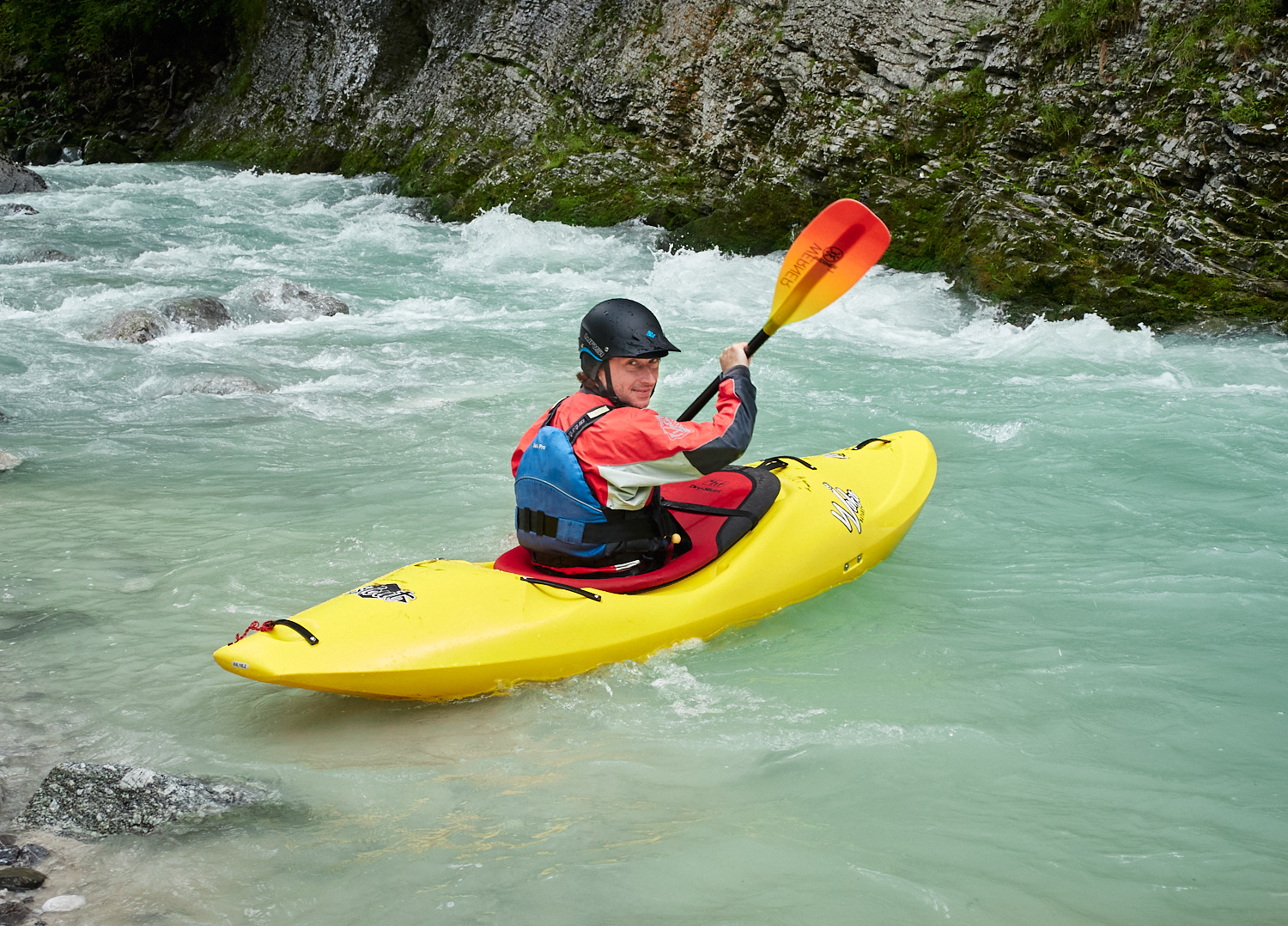 Ein Mann in seinem Kajak beim Wildwasserfahren.