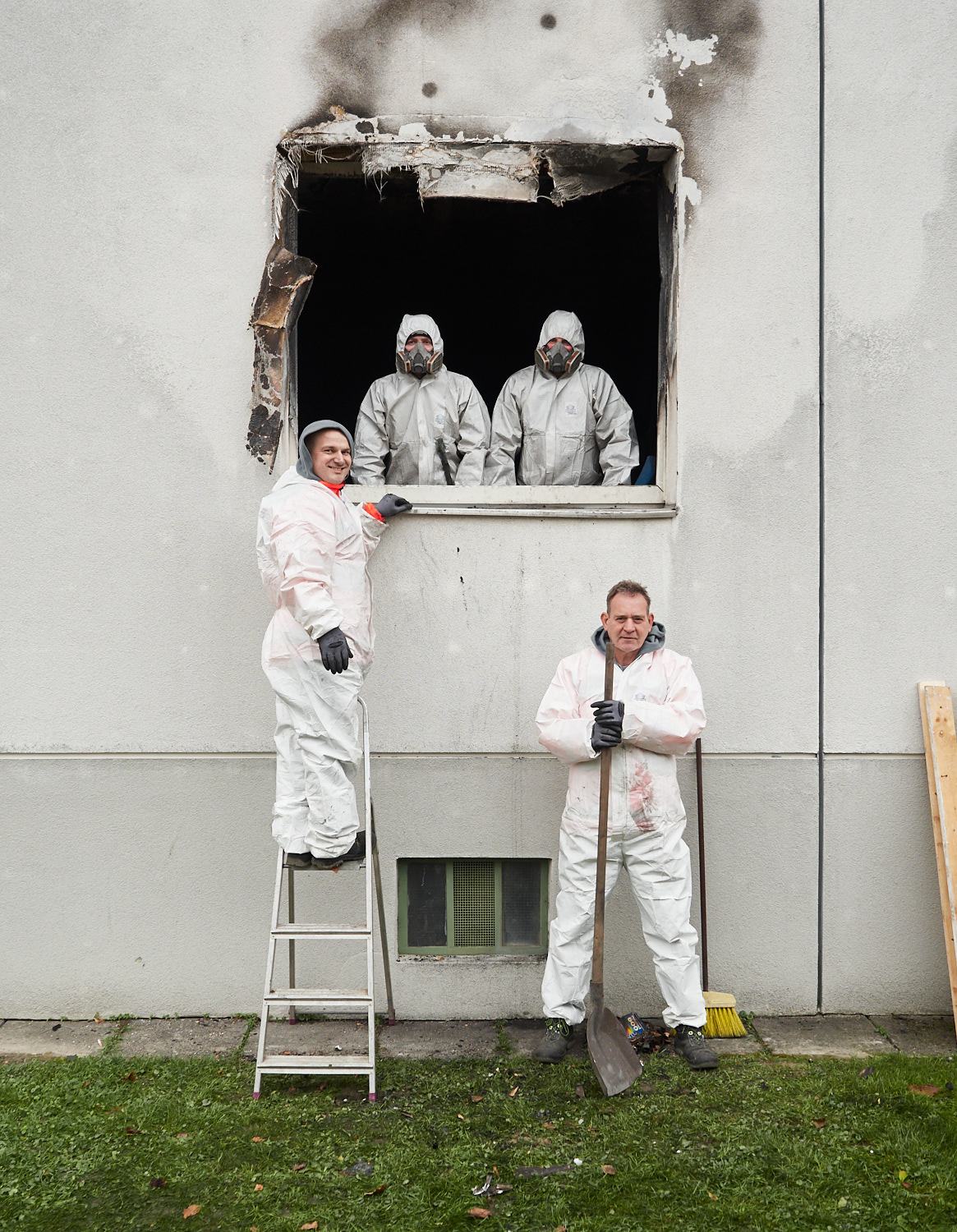 Vier Männer bei der Räumung einer ausgebrannten Wohnung.