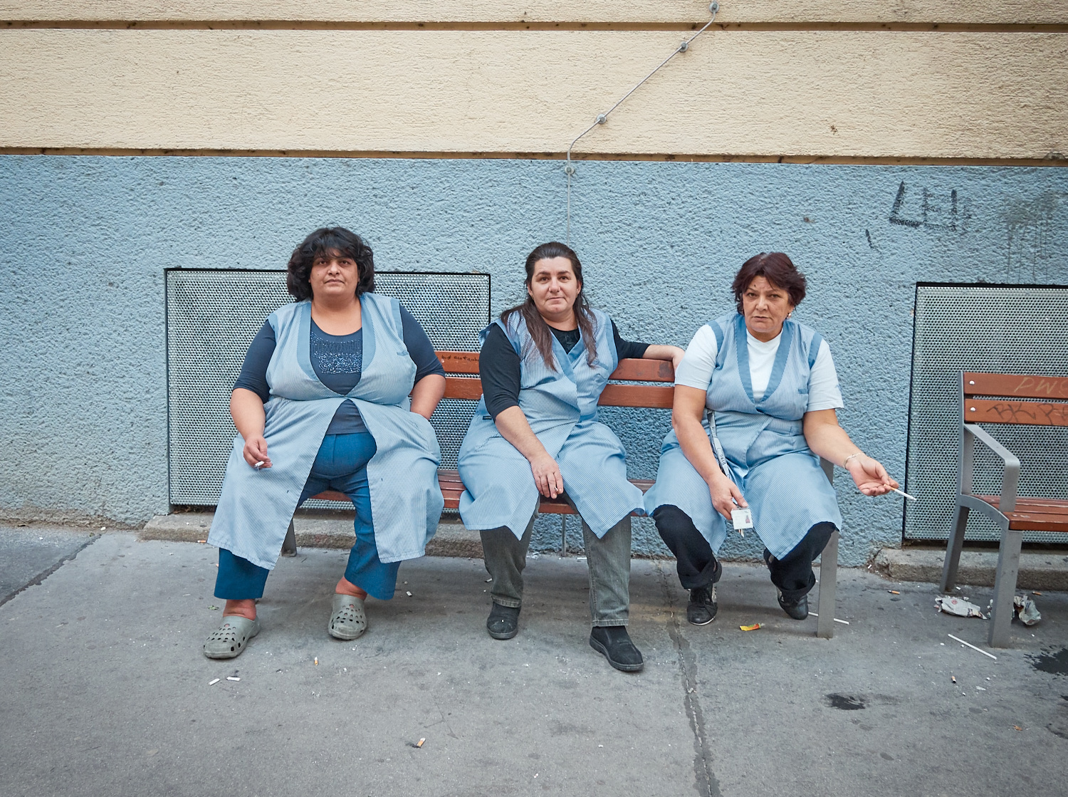 Drei weibliche Reinigungskräfte auf einer Bank bei einer Pause.